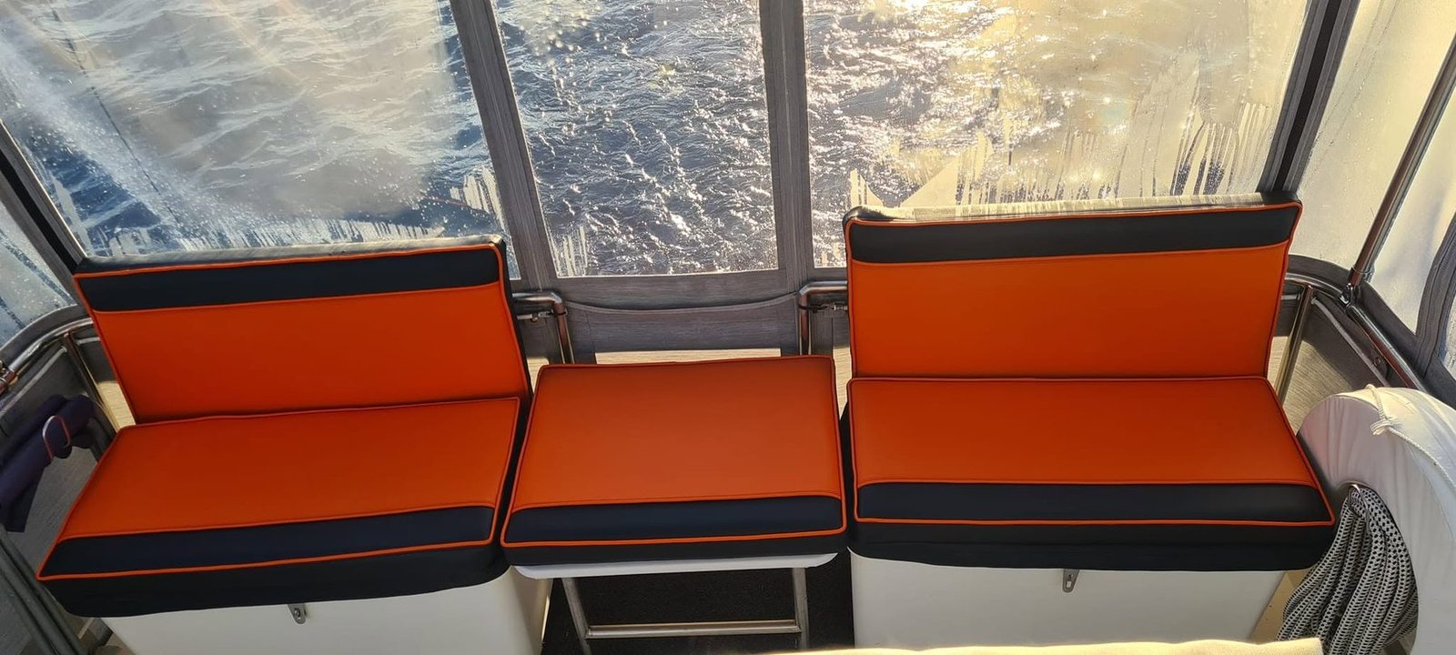 Refinished orange marine bench seating with dark contrasting trim